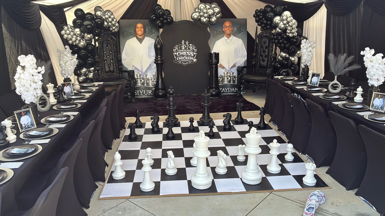 Black and white chess-themed party with throne chairs, a giant chessboard, and an elegant tablescape from Evalasting Events rentals